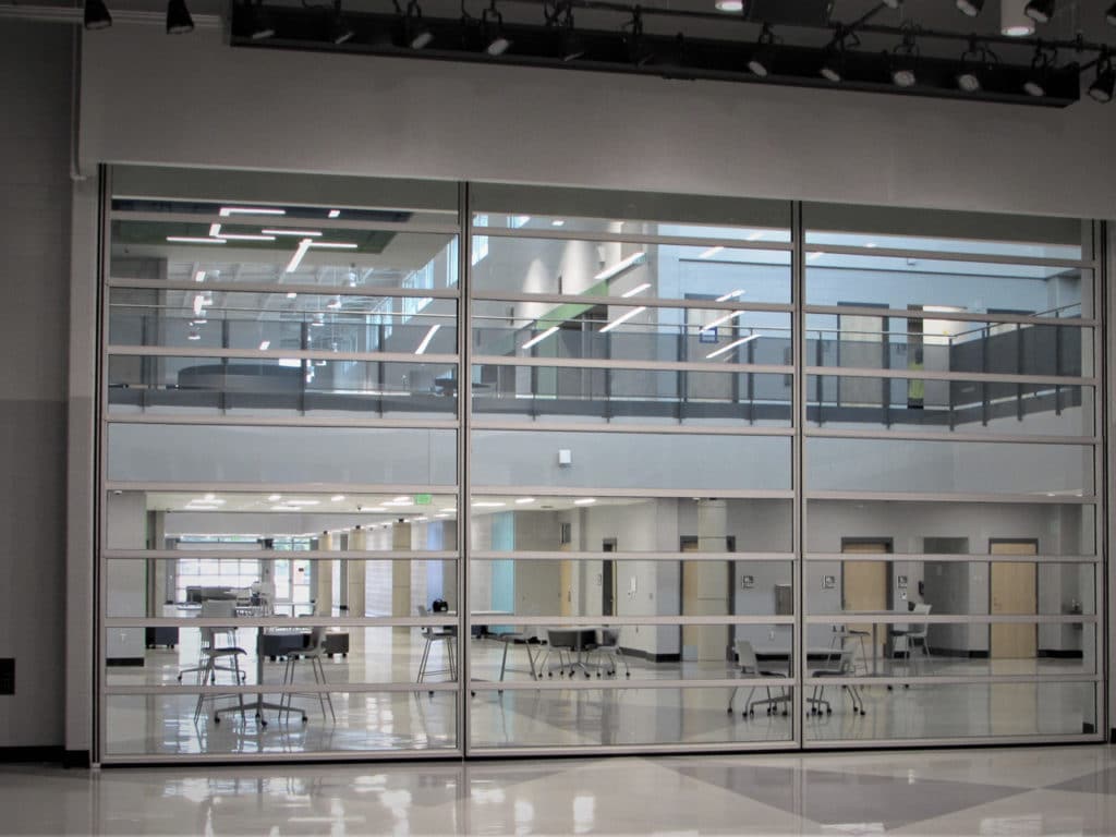 Skyfold Mirage glass operable wall fully extended in a university interior courtyard.