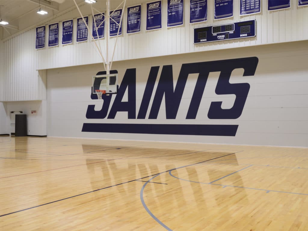 Skyfold Classic operable wall with custom graphics, fully extended in a high school gym.