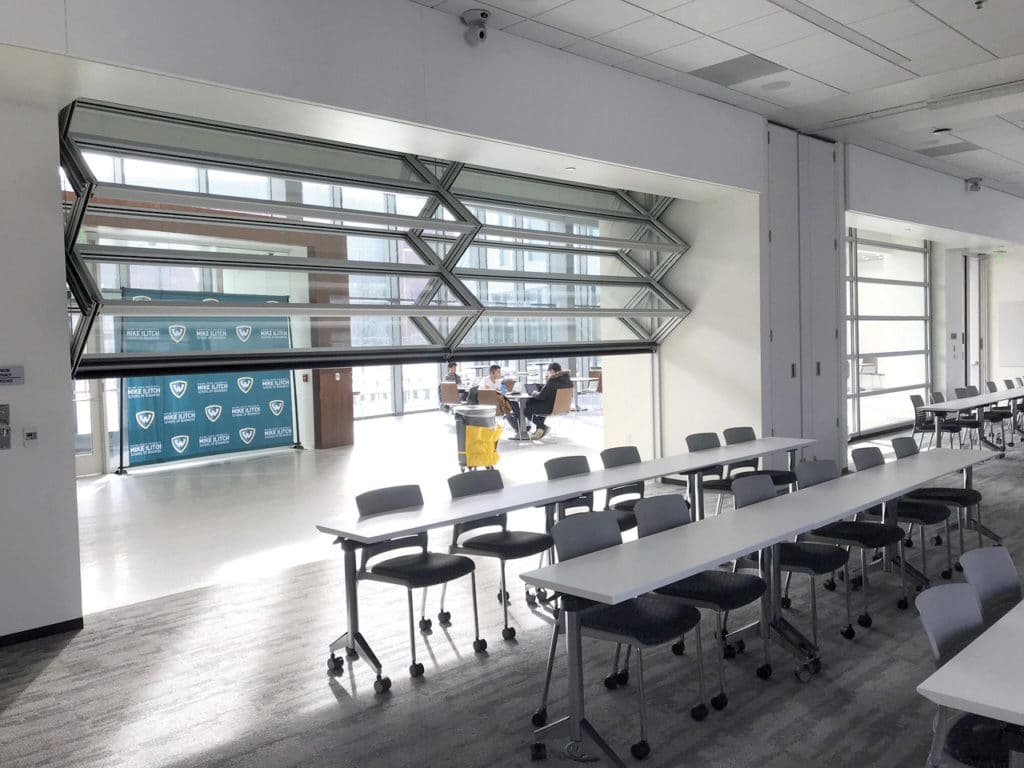 Skyfold operable glass partition halfway extended in a school.