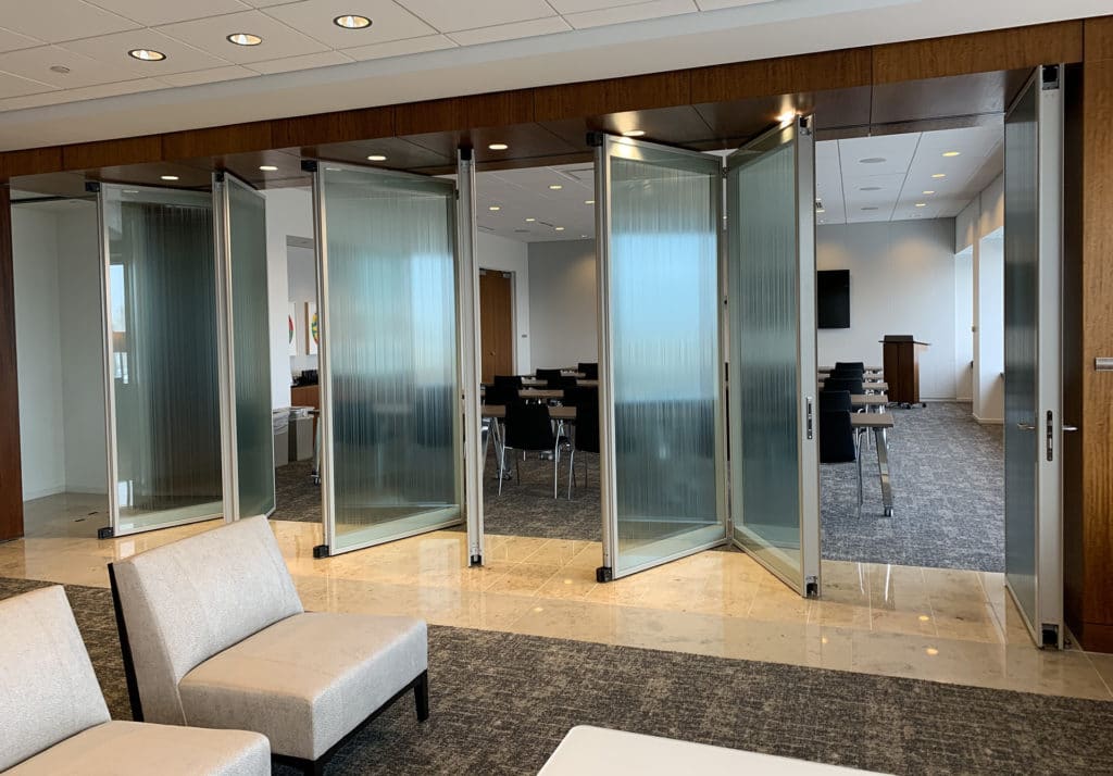 Modernfold Acousti-Clear glass wall system with panels open.