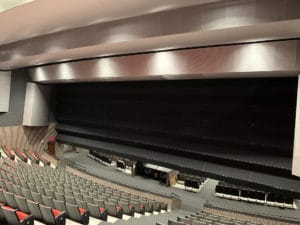 Three-quarter extended operable wall dividing a theater auditorium in half.