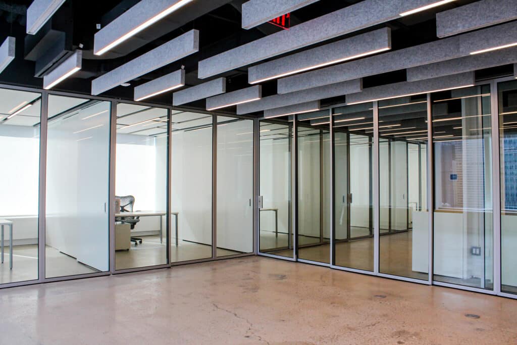 Interior of an office building with glass doors separating offices from common space.