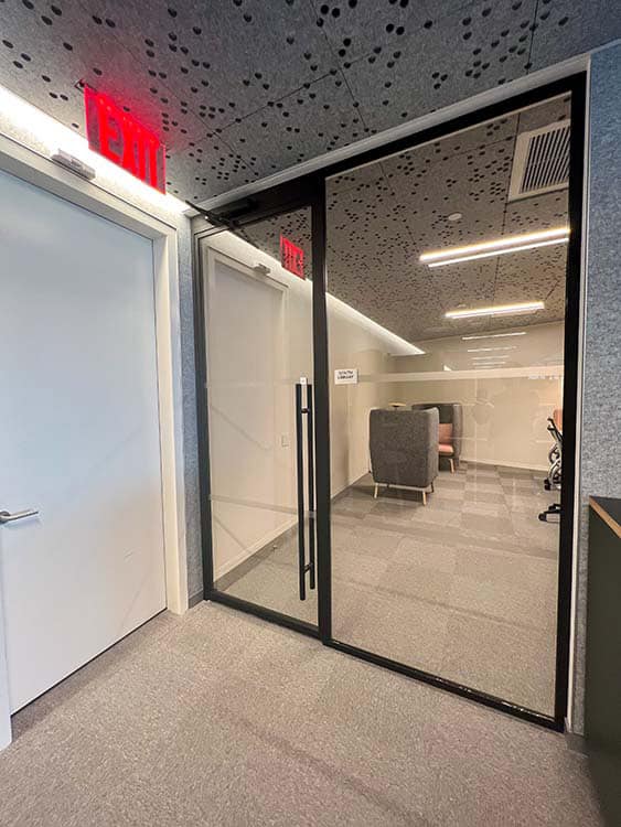 A glass door and wall separating spaces in an office.