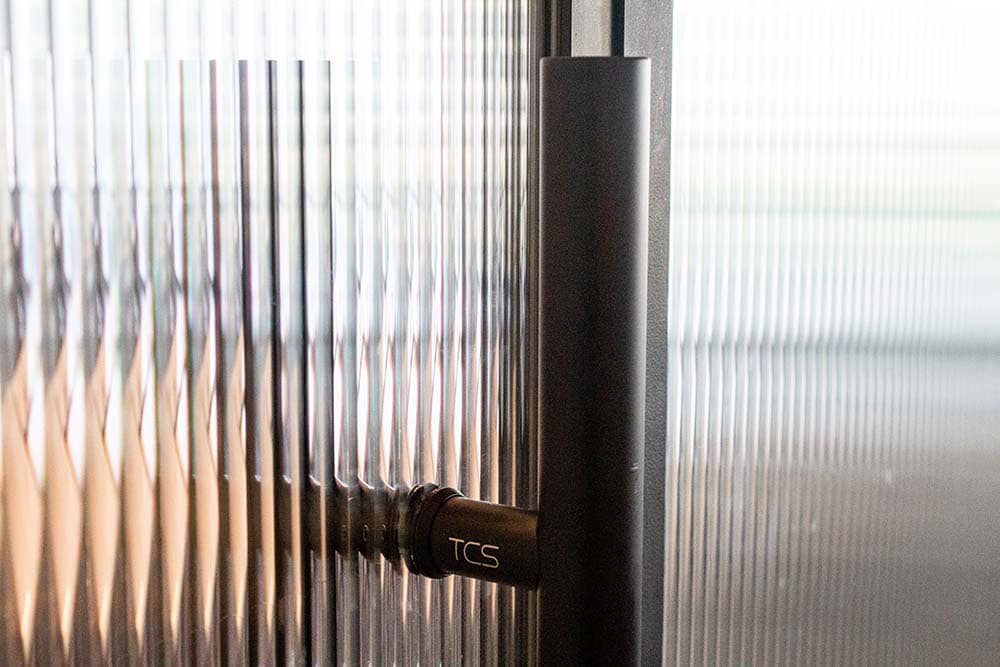 Detail of a door handle on a glass door.