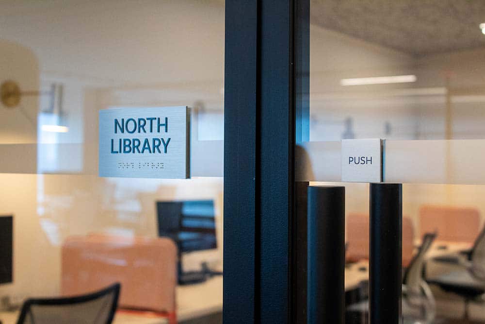 Detail of a glass door with signs that say "North Library" and "Push."