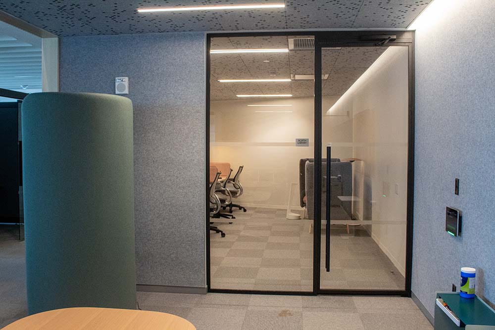 A glass door and wall separating two office spaces.